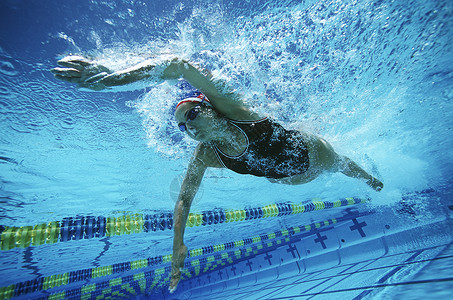 白种职业女性游泳员在游泳池游泳闲暇高清图片素材