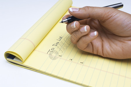 在白色背景的注纸上查找女性手写任务列表所要完成的任务组织高清图片素材