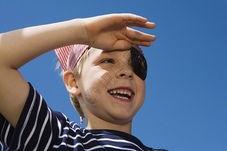 小男孩带着头巾玩耍小男孩的海盗蓝天孩子们操场摄影活动服饰孩子娱乐青少年打扮背景