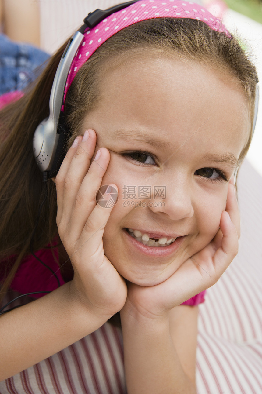 听耳语的小女孩女孩女孩们休闲耳机设备娱乐孩子们一人享受头肩音频图片