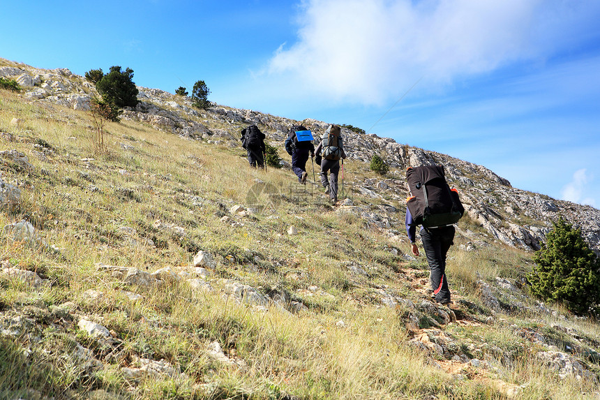 带背包的游客去山上闲暇活动天空远足者冒险蓝色晴天团体旅行爬坡图片