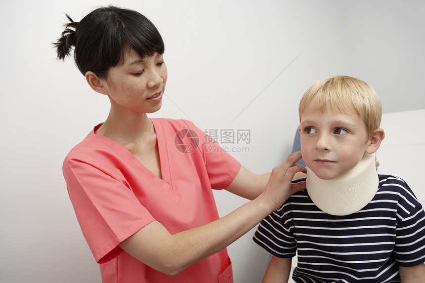 护士协助男孩在医院内戴颈套女性颈托微笑支撑医生关爱青春期医疗保健帮助图片