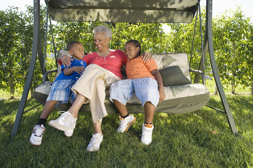外婆奶奶和孙子孙女坐在户外摇椅上图片