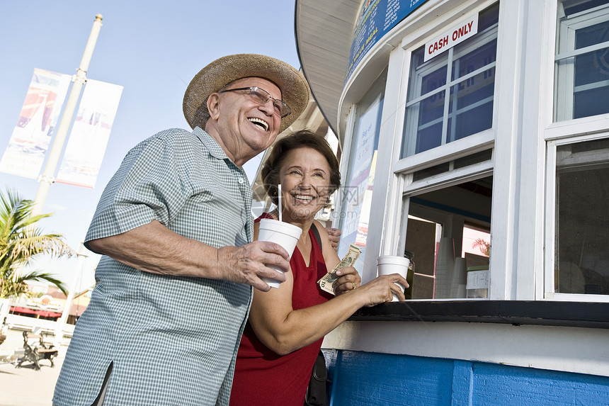 老年夫妇在食品摊买酒假期男士支付幸福退休微笑夫妻个人图片