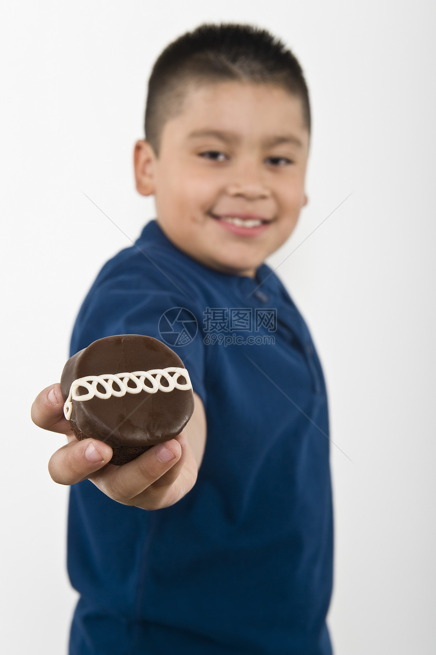 少年(10-12岁)男孩拿着饼干图片
