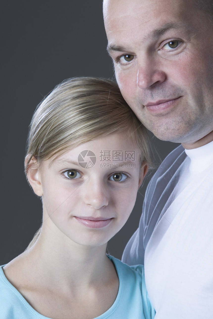 父亲和女儿微笑的演播室肖像安全中年特写视图青春期影棚头肩男子裁剪孩子图片