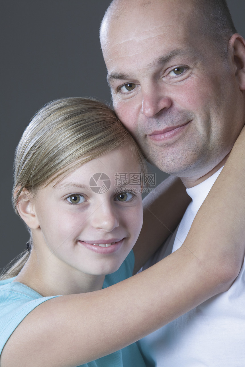 女儿拥抱父亲的摄影工作室肖像孩子微笑影棚家庭女孩男子青春期裁剪头肩视图图片