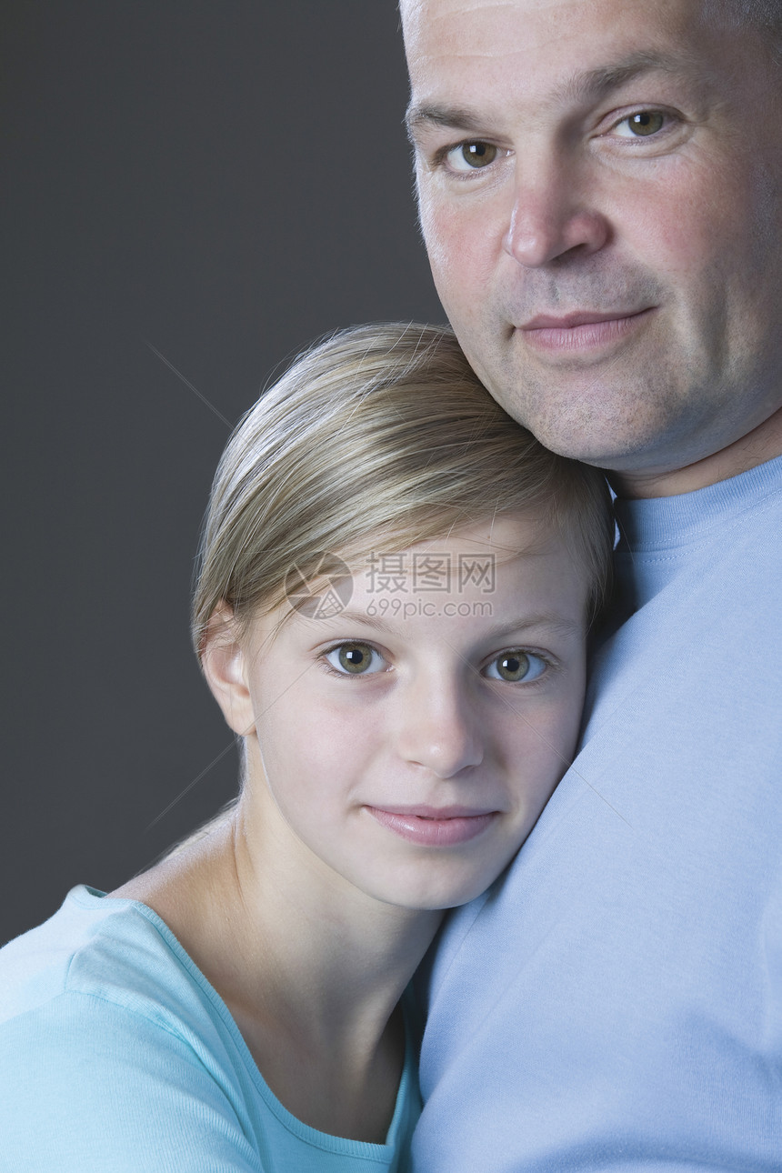 父亲和女儿微笑的演播室肖像团结安全裁剪视图男子孩子中年特写家长头肩图片