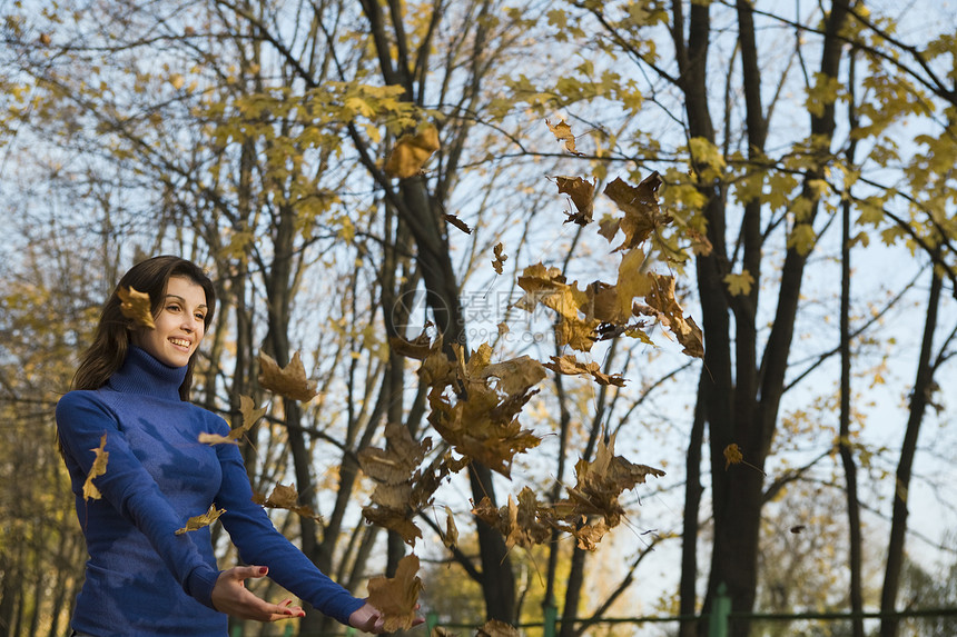 女子在公园中抓落落叶图片