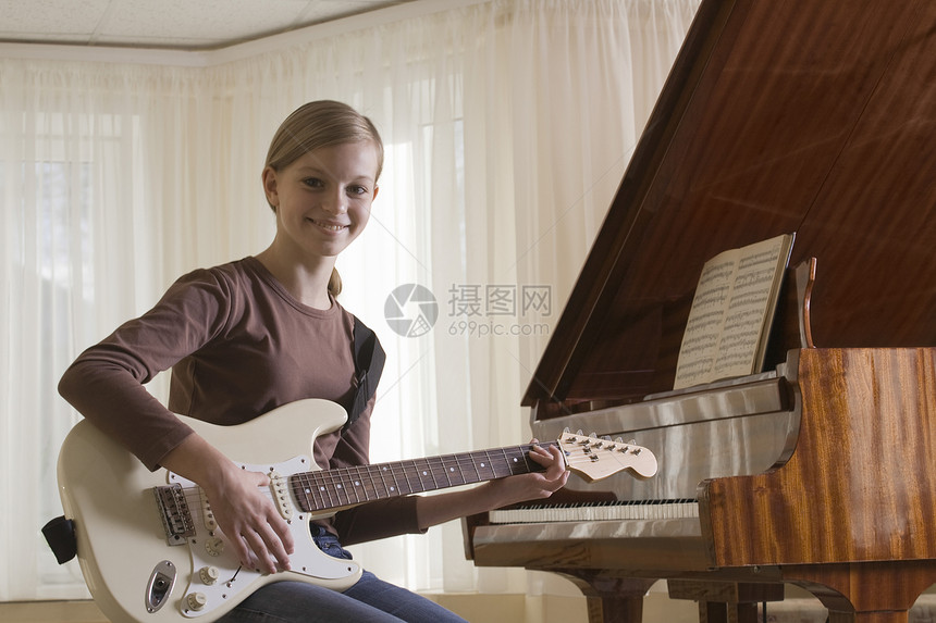 女孩1315岁弹吉他电吉他微笑学习乐器头发闲暇图片