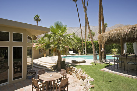 后院和现代家庭旁边的游泳池桌子草地建筑学椅子路面高清图片