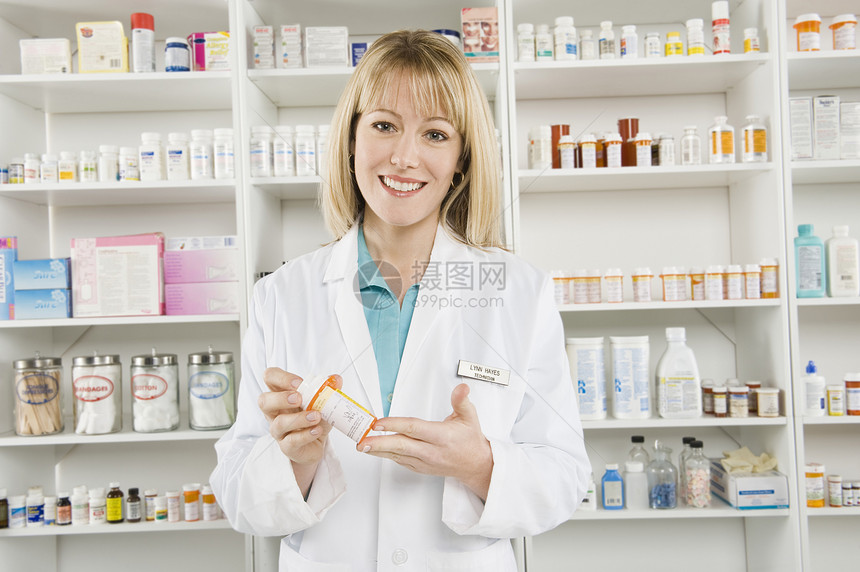 一位自信的女药剂师拿着药瓶的肖像处方保健药店店铺工作服女性实验医疗职业职场图片