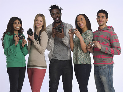 一群年轻人拿着照相机摄影棚拍摄镜头男子团结微笑女性幸福群像半身快乐影棚团体背景图片