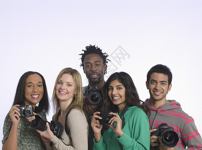 一群年轻人拿着照相机摄影棚拍摄镜头女性头肩男子快乐团结成年团体影棚友谊群像背景图片