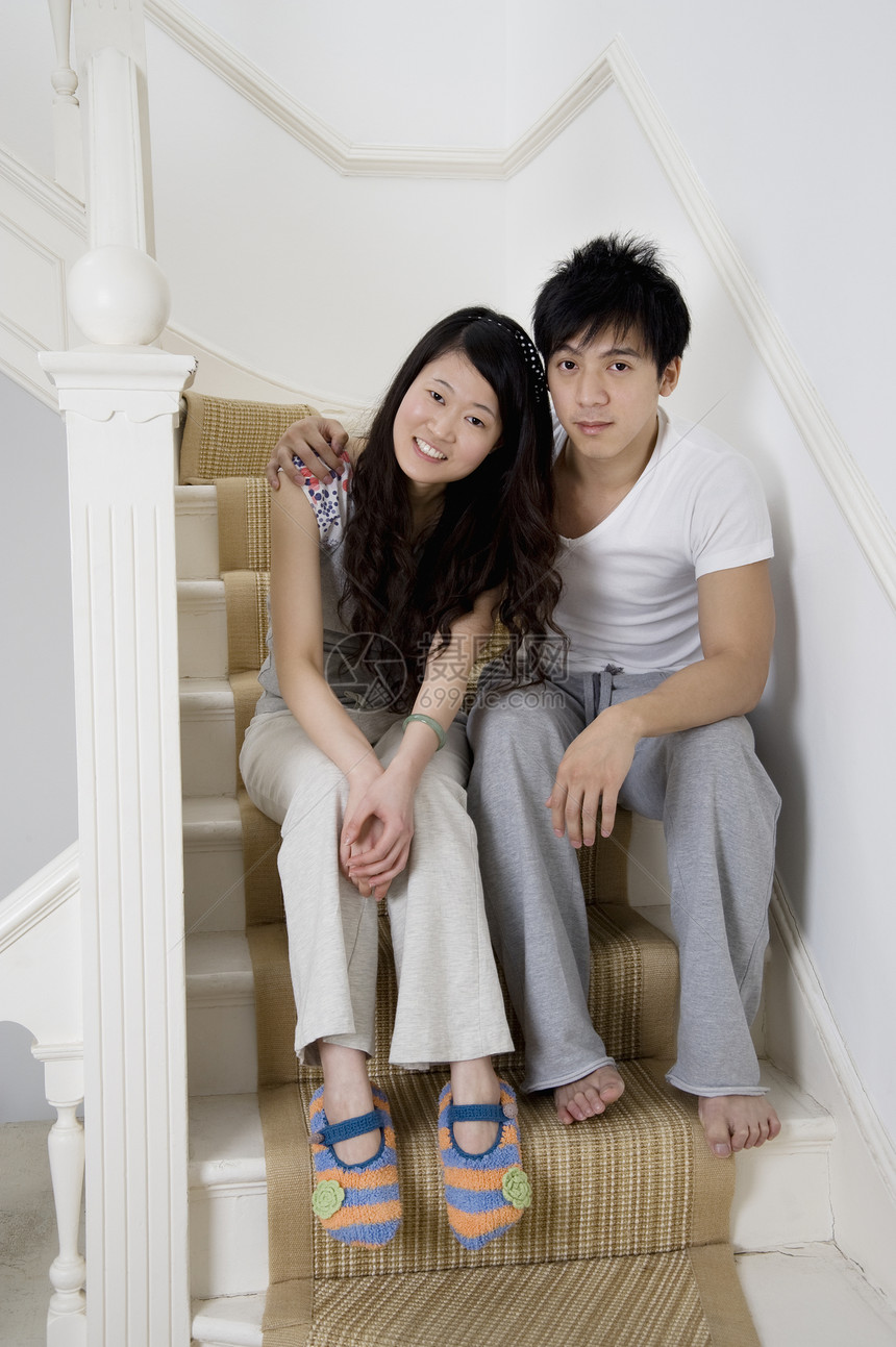 坐在楼梯上的年轻夫妇的全长肖像画图片