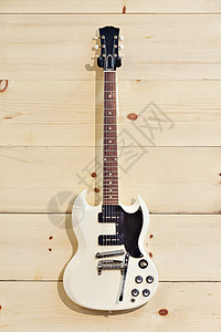 木粮墙上的白吉他背景图片