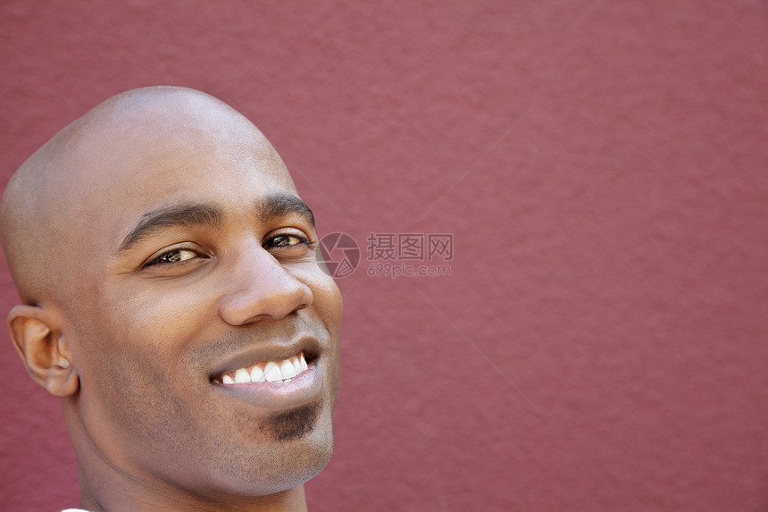 光秃的非裔美国人男子在彩色背景上的近距离肖像图片