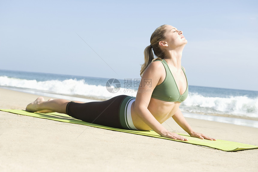 妇女在海滩上运动海洋锻炼灵活性拉伸享受眼睛闲暇运动装服装娱乐图片