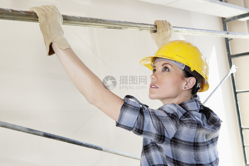 女工在建筑工地将棍子放在脚手架上图片