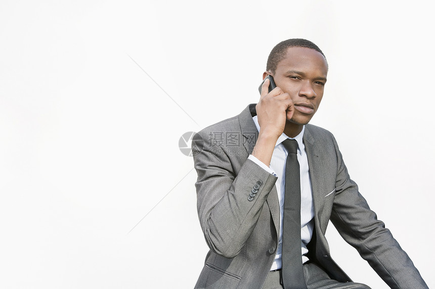 非裔美国商务人士在白色背景下用手机交谈图片
