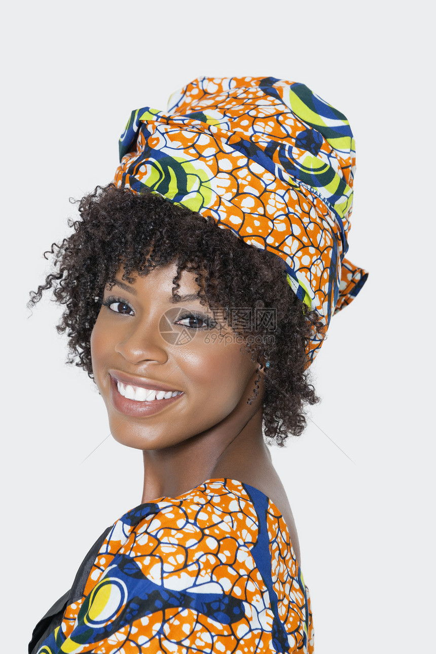 身着非洲印刷服装的年轻女性肖像在灰色背景下肩并肩看图片