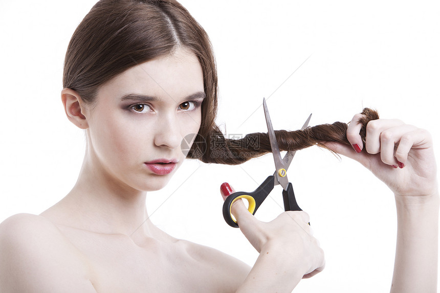 美丽的年轻女人的肖像 用剪刀剪发 在白背景上剪头发