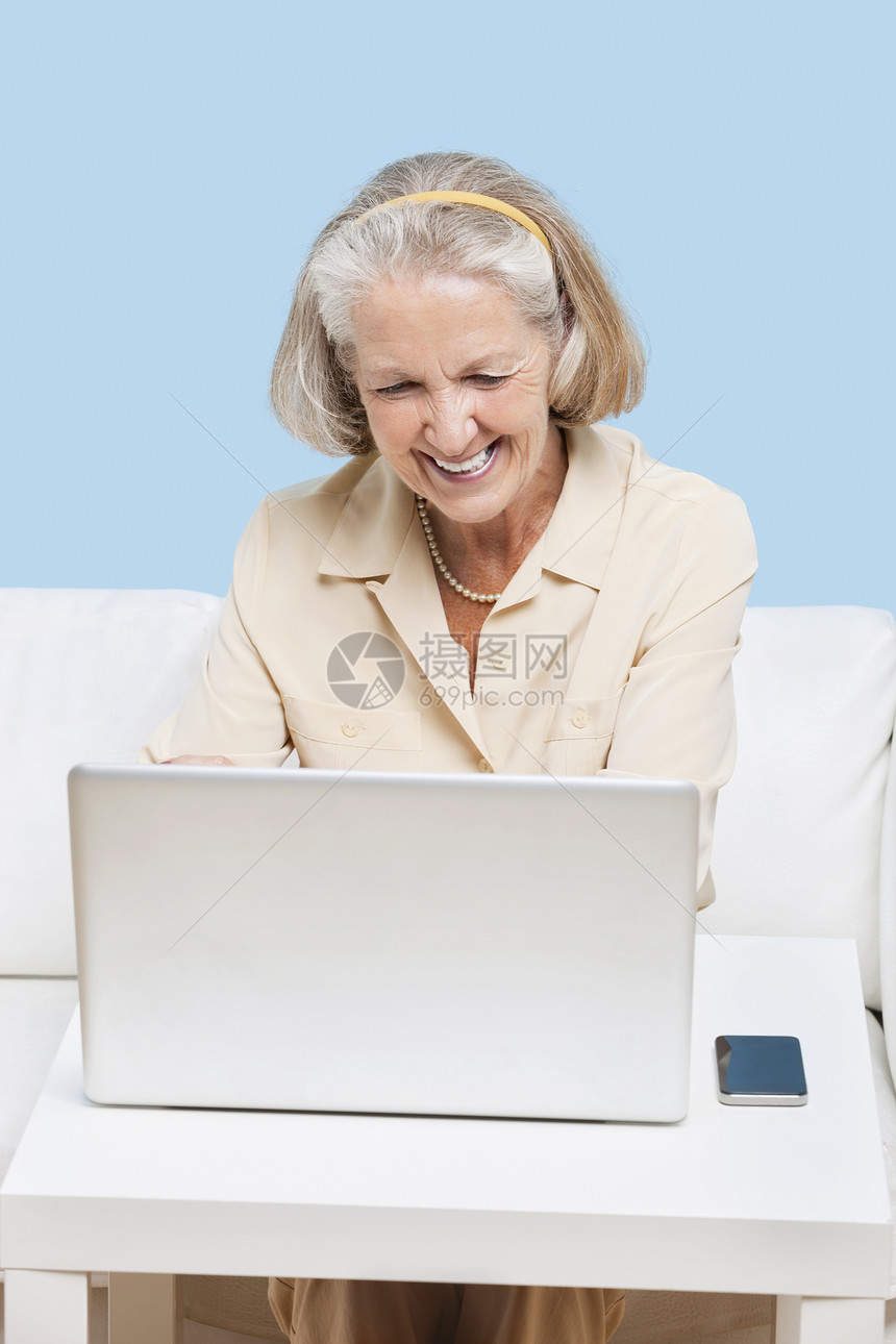 使用笔记本电脑进行视频通话的年长妇女退休喜悦白发沙发微笑手机用户短发计算机女性图片