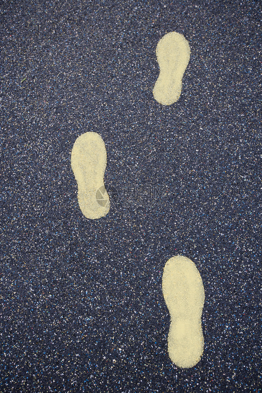 在操场橡胶地板上绘制的黄色脚步图片