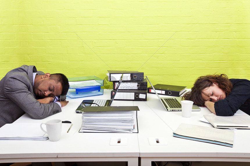 同事在各自的办公桌睡着文件夹成人商业生意人笔记女性睡眠商界工作男性图片