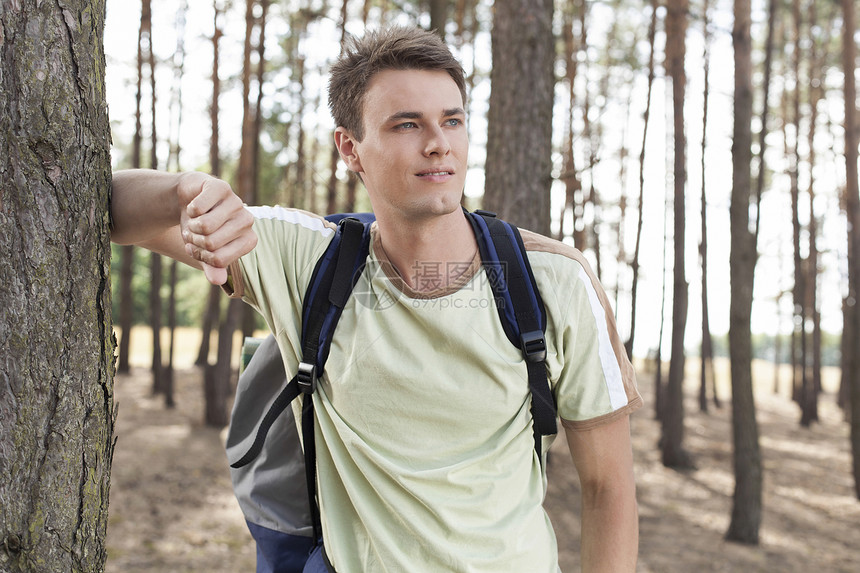 快乐的年轻人带着背包在树林中徒步图片
