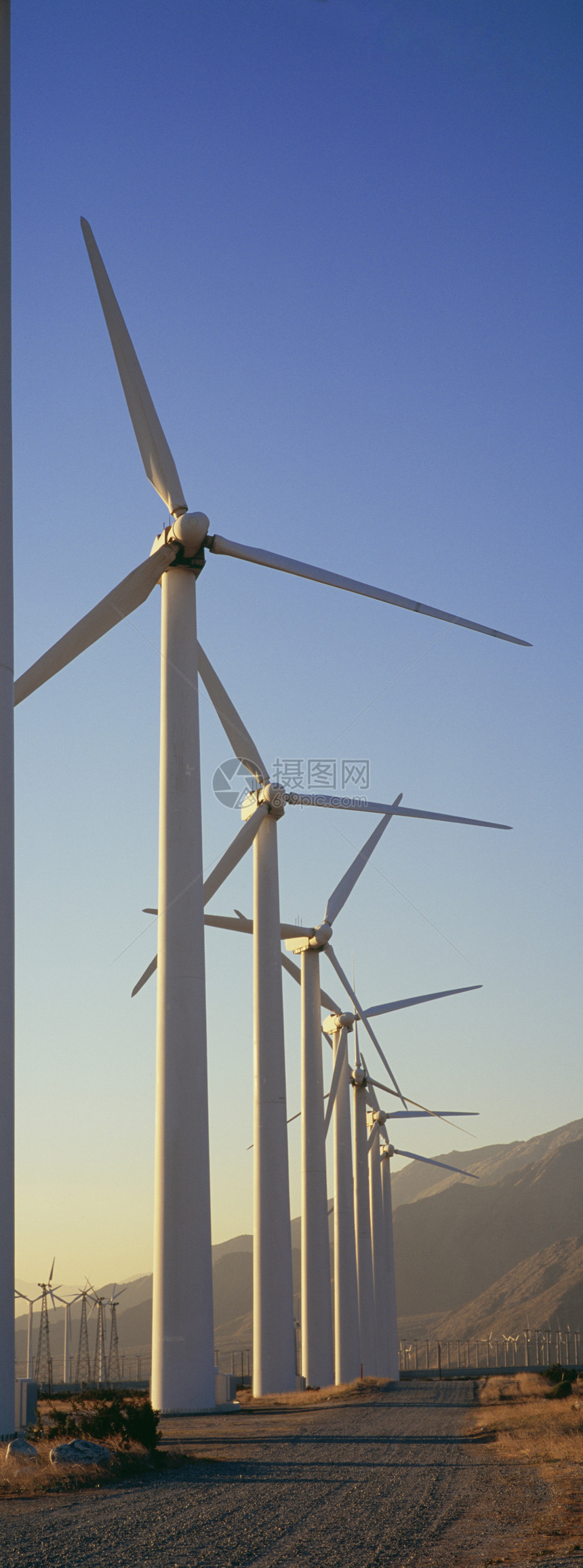 山脉前面的产生风力车行发电站列全景技术能源纺纱节能人行道道路风车设备阳光图片