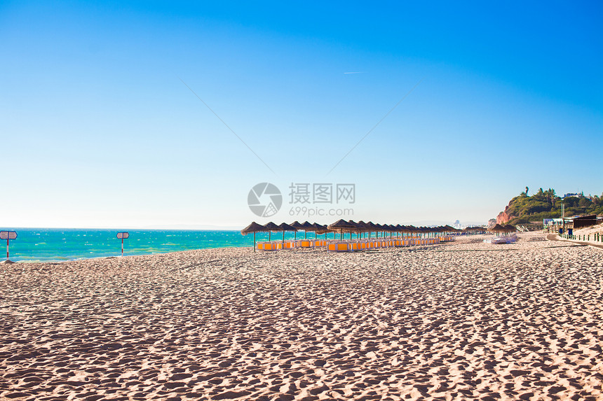 清晨在葡萄牙海岸的空沙滩上 有封闭的雨伞异国假期晴天情调场景闲暇日落风景海洋天空图片