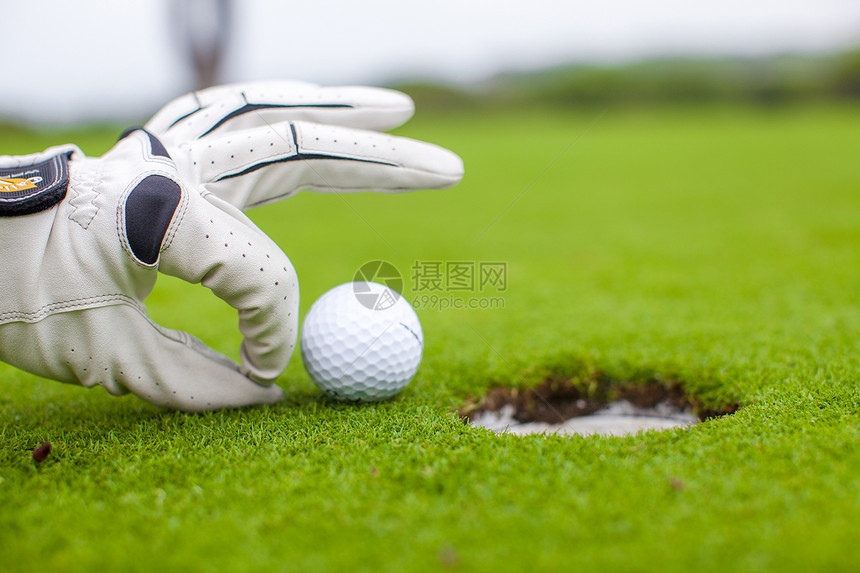 高尔夫球运动员把高尔夫球推进洞里推杆俱乐部场地手套竞赛游戏男性玩家男人手指图片