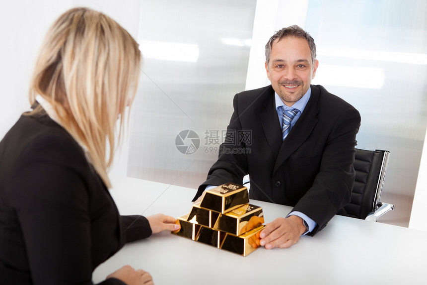 接受金条的商务人士女性顾问会议雇主人士办公室成功宝藏投资利润图片