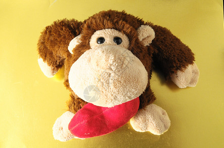 有趣的棕色猴子动物手工玩具熊娃娃白色羊毛乐趣礼物红色针织背景图片