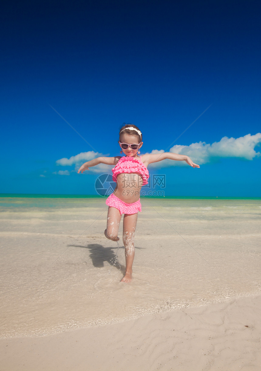 小女孩在白沙滩上张开双臂女性自由异国情调支撑海岸线热带乐趣旅游快乐图片