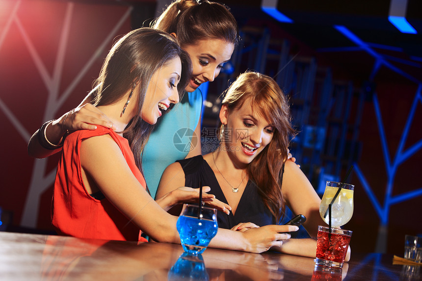 与智能手机玩得开心幸福快乐色彩酒吧饮料女性青年俱乐部娱乐派对图片