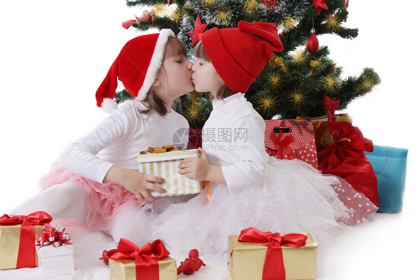两个小姐妹在圣诞树下亲吻图片
