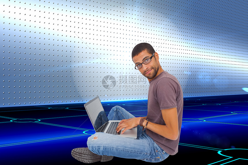 男子用笔记本电脑坐在地板上并观看照相机戴眼镜的复合图像技术胡子牛仔布蓝色计算胡须男性男人数字绘图图片