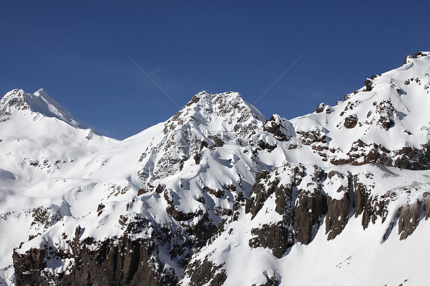 云中的山岳冰川阴霾单板暴风雪顶峰天空太阳高度蓝色滑雪图片