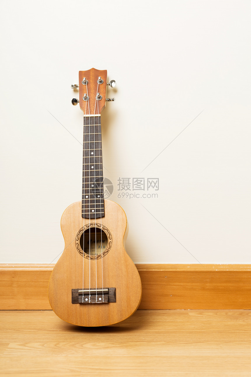 Ukulele在地板上孩子艺术歌曲吉他木头娱乐电线竹子白色棕色图片