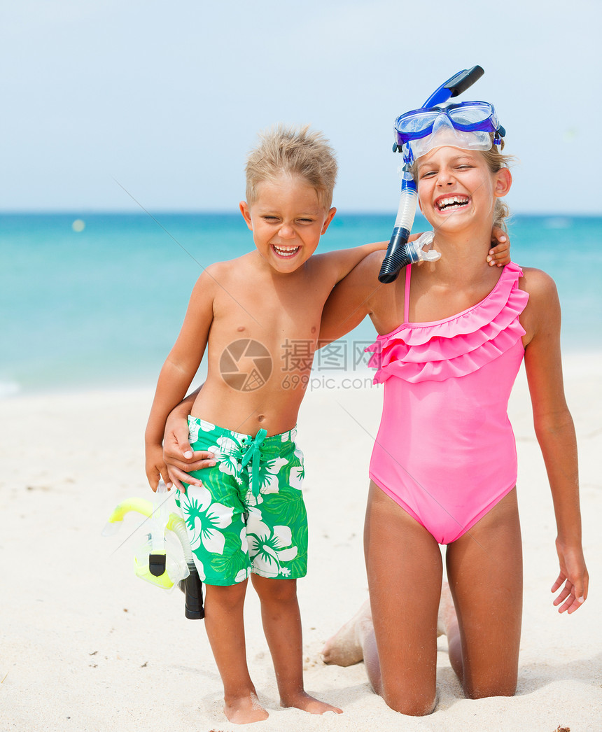 在海滩上快乐的孩子们天空享受海洋呼吸管女孩兄弟闲暇潜水浮潜蓝色图片
