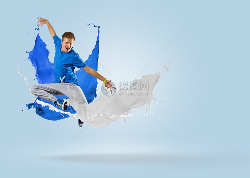 年轻男舞蹈者随涂料喷洒跳跃休息运动霹雳舞行动舞蹈舞蹈家蓝色杂技身体艺术图片