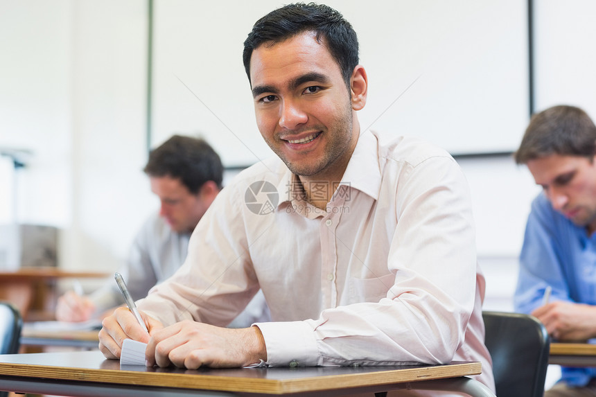 在课堂做笔记的成熟学生衬衫专注桌子写作教育课程男性注意力演讲大学图片