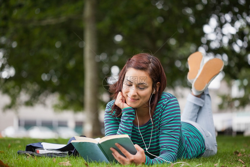 躺在草地上看书的微笑临时学生图片