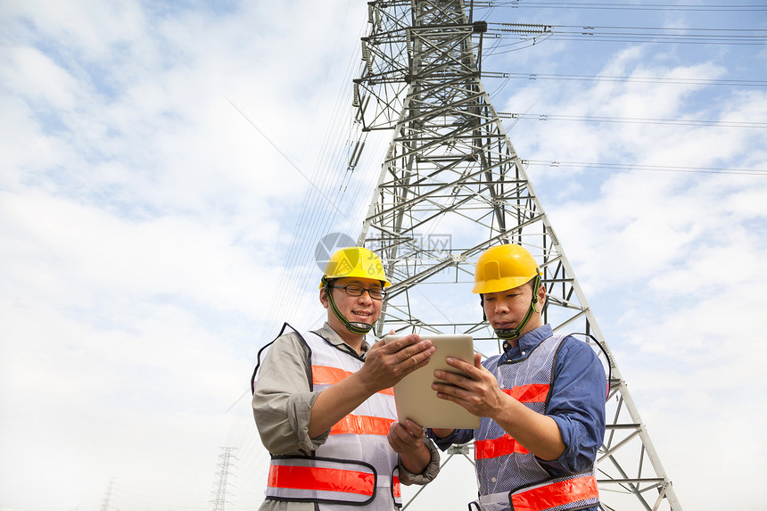 两名工人站在电塔前的电线塔前药片工程师电讯头盔力量承包商服务建筑安全男人图片
