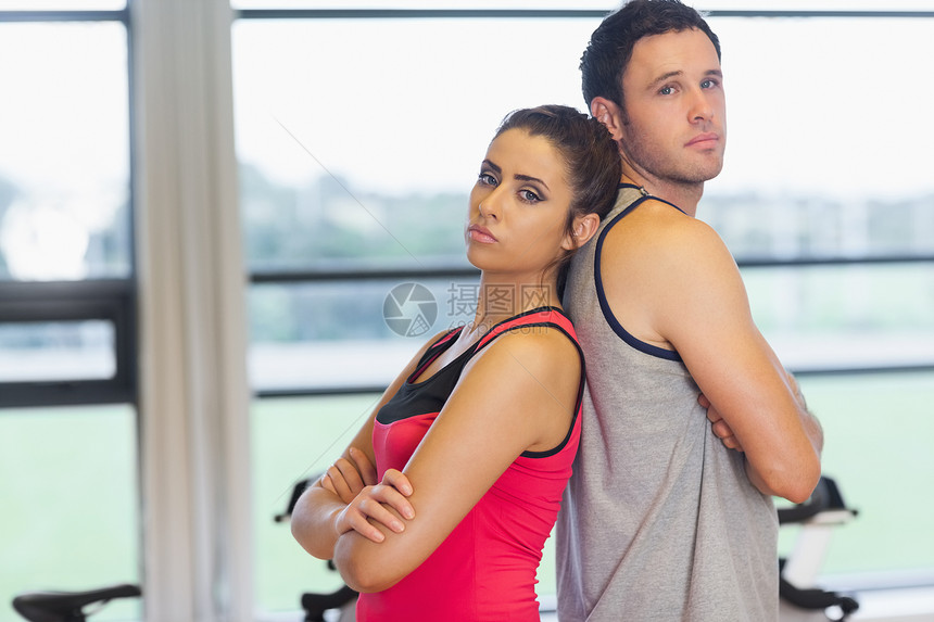 在健身房里 严肃的男女男人和女人站在后面图片
