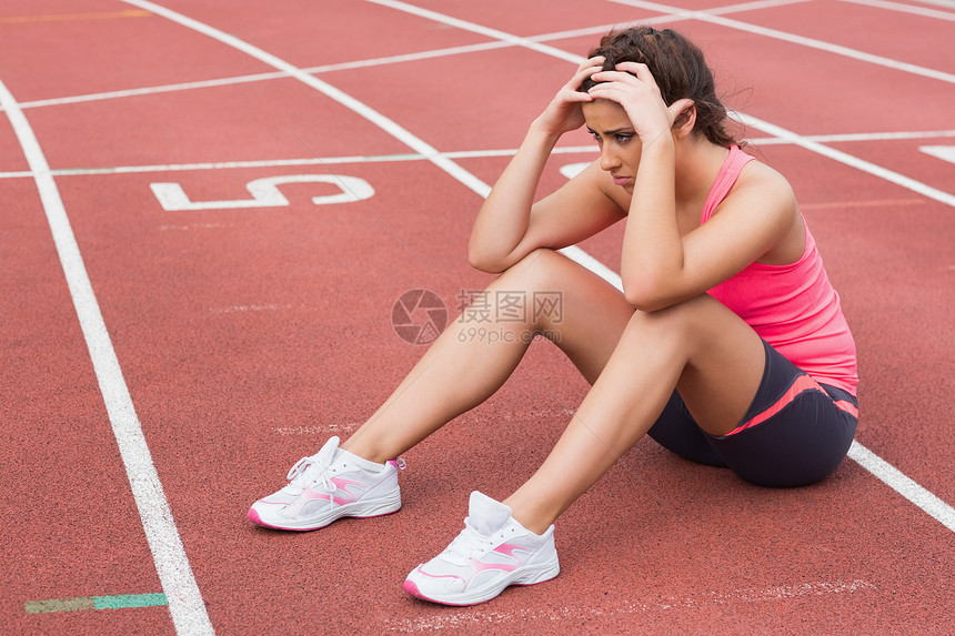 坐在赛道上的年轻运动女青年身体赛跑者运动员女士短裤闲暇生活方式休息体育场女性图片