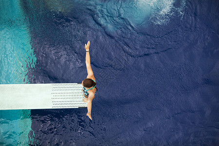 跳水台高潜水员太阳自由蓝色游泳池女性游泳飞跃活动运动潜水背景