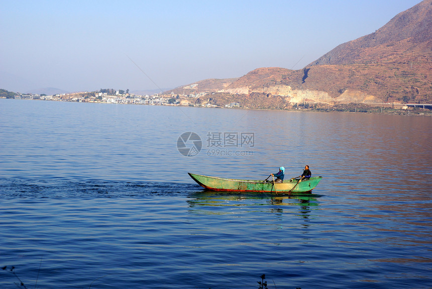 中国云南省达利埃海尔湖捕鱼者渔夫工作平衡旅行镜子独木舟天空日出反射爬坡图片